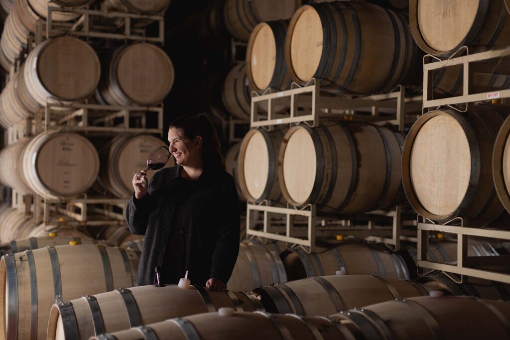 Winemaker Katie Vogt in cellar with barrels of Pahlmeyer wine.